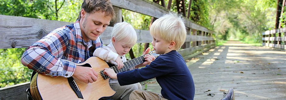 Père qui joue de la guitare avec ses enfants