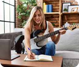Musicienne jouant de la guitare électrique et prenant des notes